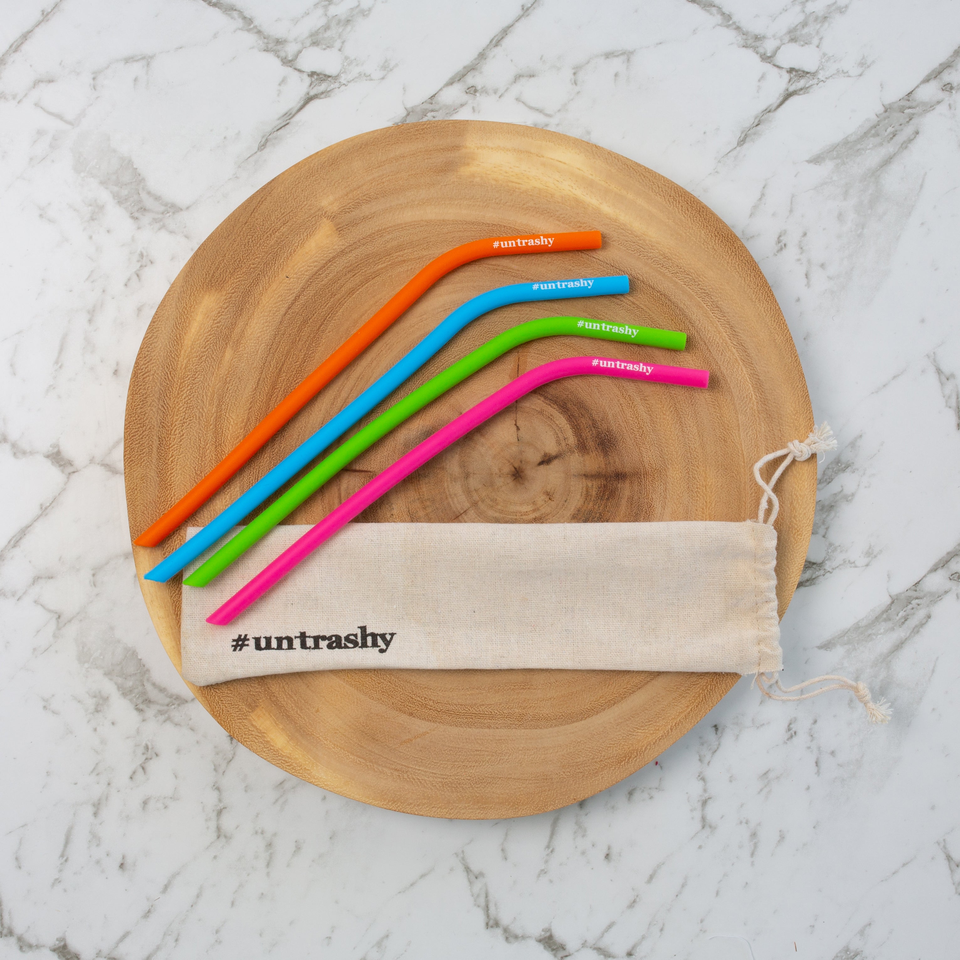 colourful silicone straws with a straw bag on a wooden board