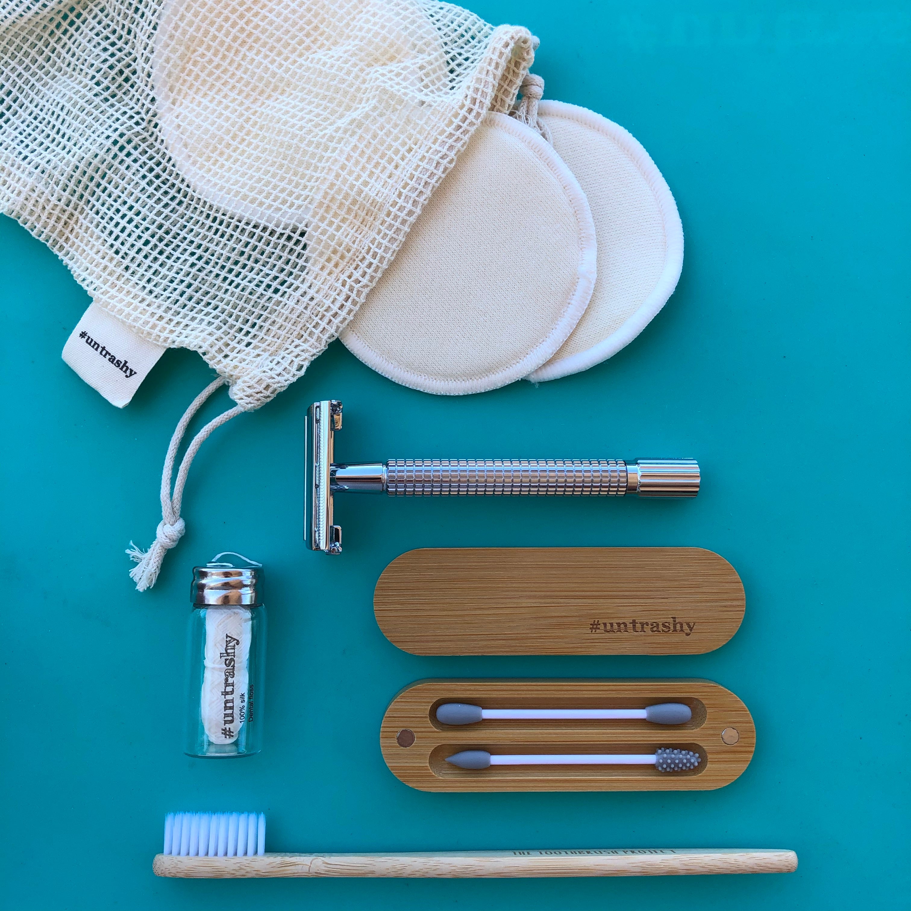 variety of beauty products on a teal background